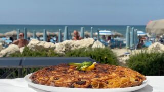 C'è chi vieta ai bagnanti di portare cibo da casa, e chi invece addirittura li premia. L'8 agosto, presso il lido Sabbia d'Argento, a Varcaturo, si è tenuta la prima edizione di "Ho fatto la frittata", una vera e propria sfida gastronomica, nata con l'obiettivo di lanciare un messaggio chiaro: il pranzo a sacco in spiaggia è un diritto di ogni cittadino. Tra ricette innovative e tradizionali, i bagnanti si sono sfidati, trasformando una giornata di mare in un momento di convivialità e divertimento anche grazie all'intrattenimento del comico Ciro Giustiniani.